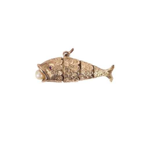 628 - A 9ct gold articulated fish pendant with ruby set eyes and a pearl in its mouth, 3.8cms long, 9.2g.