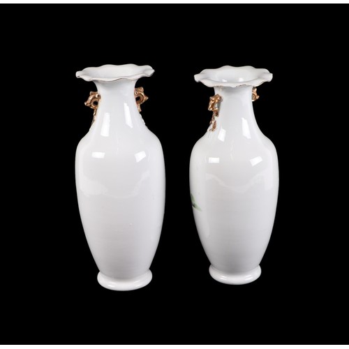 709 - A pair of Chinese famille rose vases decorated with figures in a landscape, 28cms high.