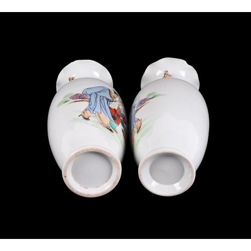 709 - A pair of Chinese famille rose vases decorated with figures in a landscape, 28cms high.