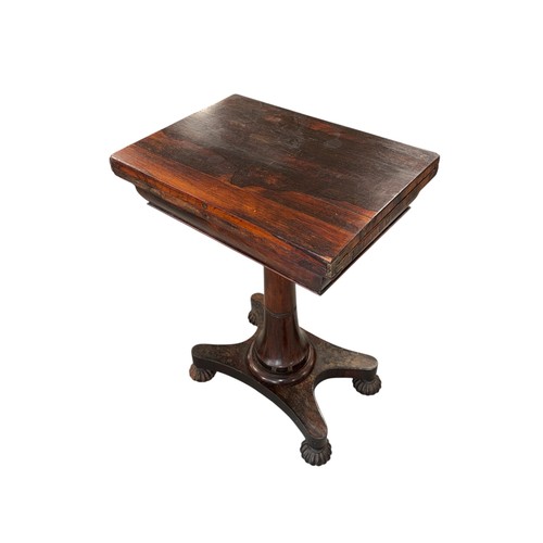A Regency rosewood games table, the rectangular top swivelling to open ...