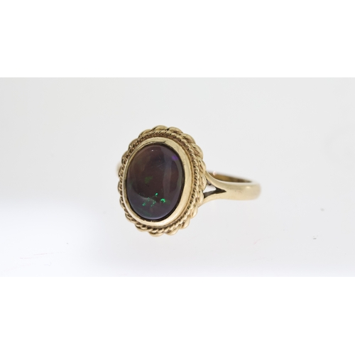 1294 - BLACK OPAL RING,  central oval cut cabochon black opal, approx 11x9mm, rope edge boarder, hallmarked... 