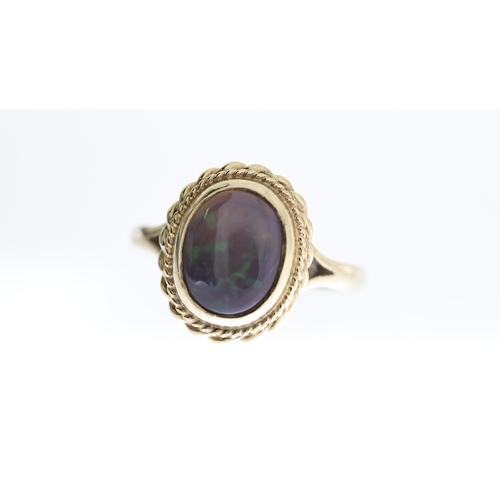 1294 - BLACK OPAL RING,  central oval cut cabochon black opal, approx 11x9mm, rope edge boarder, hallmarked... 