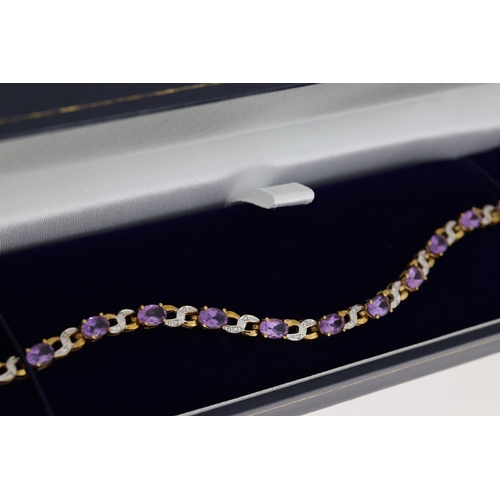 1076 - 9ct yellow gold amethyst and diamond figure-of-eight bracelet, boxed. Oval-cut amethysts 5.50ct appr... 