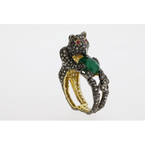 1087 - Unusual silver gilt panther ring heavily-set with diamonds. The panther is holding an oval emerald a... 