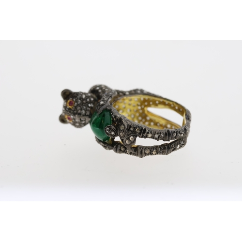 1087 - Unusual silver gilt panther ring heavily-set with diamonds. The panther is holding an oval emerald a... 