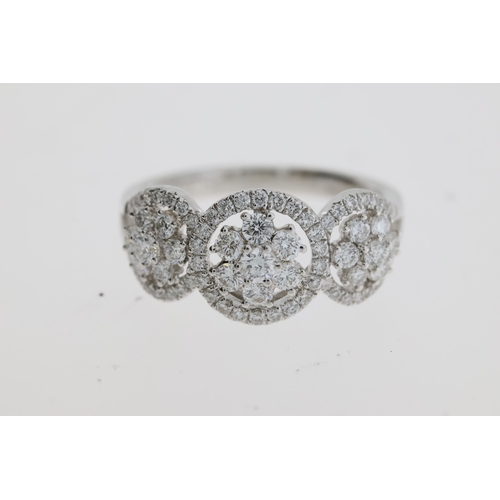 1117 - A pretty flower cluster diamond ring, 3 flowers
each set inside a halo of diamonds. Estimated to
be ... 