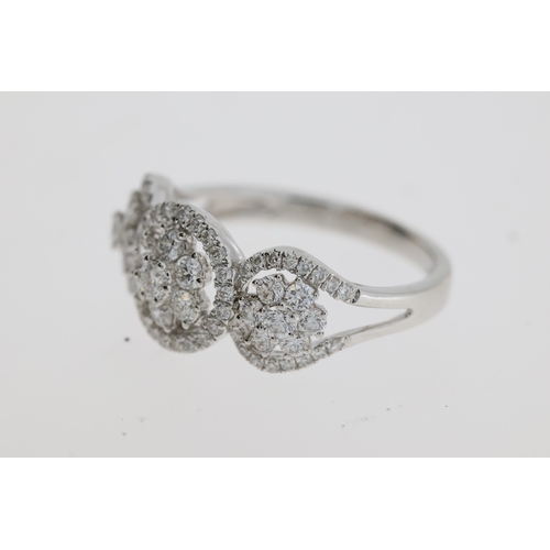 1117 - A pretty flower cluster diamond ring, 3 flowers
each set inside a halo of diamonds. Estimated to
be ... 