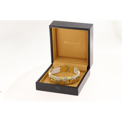 1015 - 18ct yellow and white gold diamond set Bulgari bangle. Flexible torque style with diamond set sectio... 