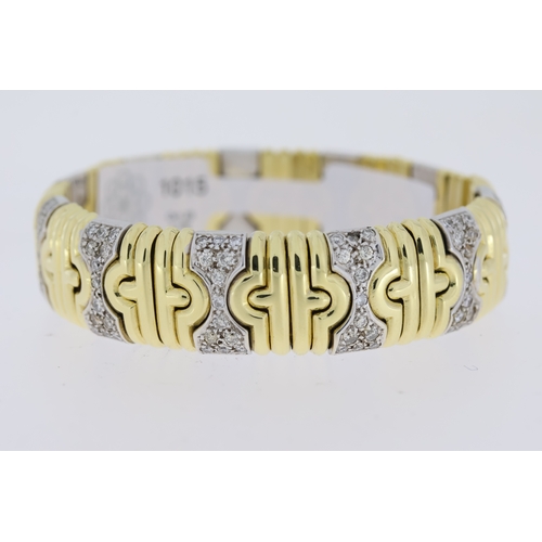 1015 - 18ct yellow and white gold diamond set Bulgari bangle. Flexible torque style with diamond set sectio... 