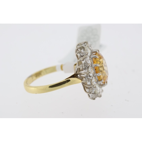 1029 - Imperial Topaz and diamond cluster ring. Faceted golden topaz surrounded by round brilliant cut diam... 