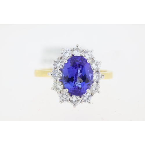 1031 - 18ct yellow gold Tanzanite and diamond cluster ring. Centre oval tanzanite approx 2.00ct.