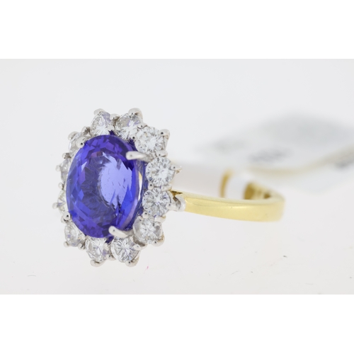 1031 - 18ct yellow gold Tanzanite and diamond cluster ring. Centre oval tanzanite approx 2.00ct.