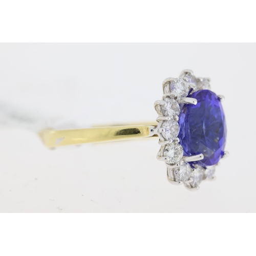 1031 - 18ct yellow gold Tanzanite and diamond cluster ring. Centre oval tanzanite approx 2.00ct.