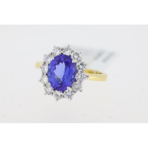 1031 - 18ct yellow gold Tanzanite and diamond cluster ring. Centre oval tanzanite approx 2.00ct.