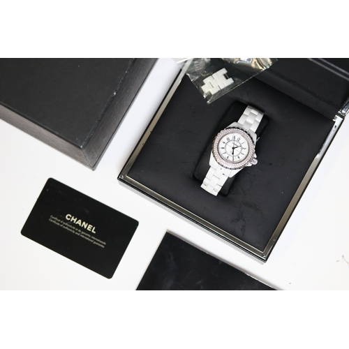 23 - LADIES CHANEL J12 WHITE CERAMIC DIAMOND BEZEL BOX AND PAPERS 2009, circular white dial with arabic n... 