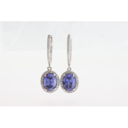 1002 - A pair of 18ct white gold tanzanite drop earrings.