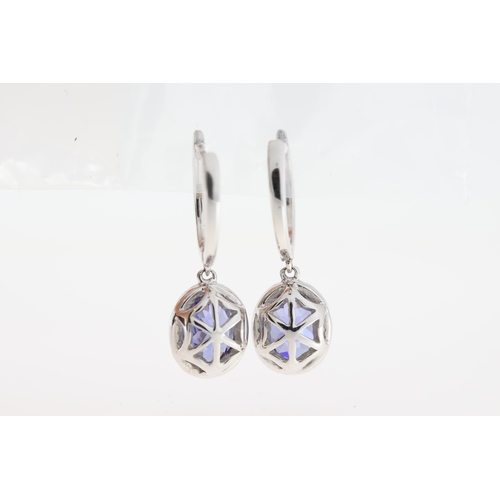 1002 - A pair of 18ct white gold tanzanite drop earrings.