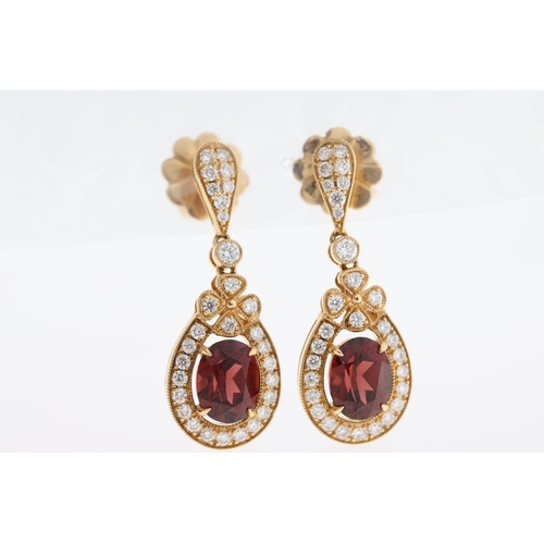 1003 - A pair of 18ct garnet & diamond drop earrings.