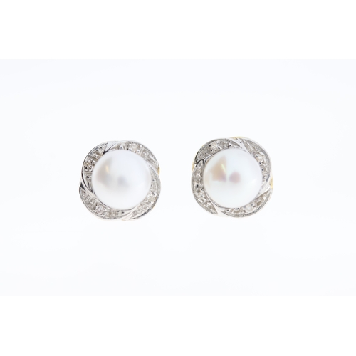 1004 - A paif of 9ct pearl & diamond stud earrings.