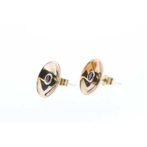 1012 - A pair of 9ct ruby studs.