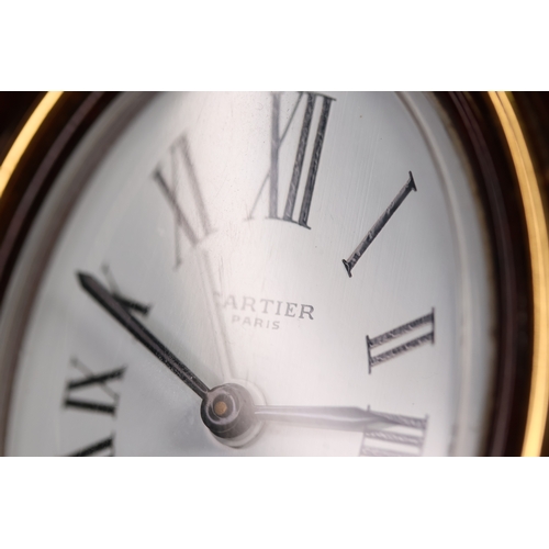 175 - A Cartier faux tortoiseshell oval cased desk/bedside alarm clock. Ref '7509 - 20863'. A white oval d... 