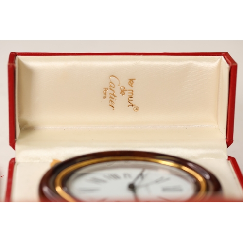 175 - A Cartier faux tortoiseshell oval cased desk/bedside alarm clock. Ref '7509 - 20863'. A white oval d... 