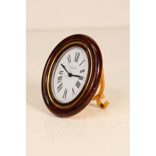 175 - A Cartier faux tortoiseshell oval cased desk/bedside alarm clock. Ref '7509 - 20863'. A white oval d... 