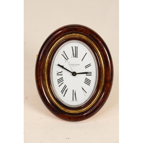 175 - A Cartier faux tortoiseshell oval cased desk/bedside alarm clock. Ref '7509 - 20863'. A white oval d... 