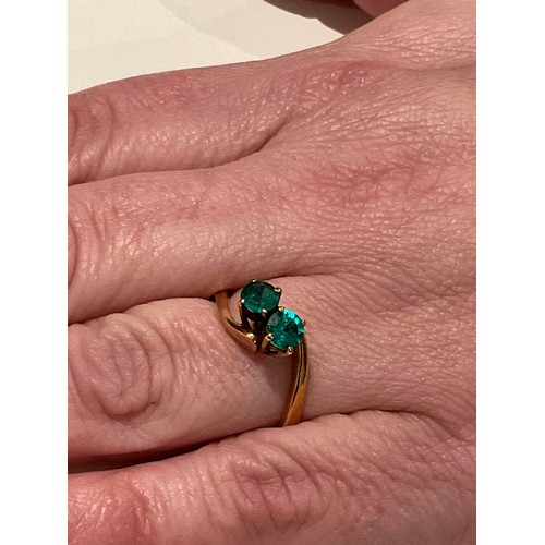 15 - 18ct gold ring with 2 x deep royal green colour stones brilliant cut with cross over yellow gold mou... 