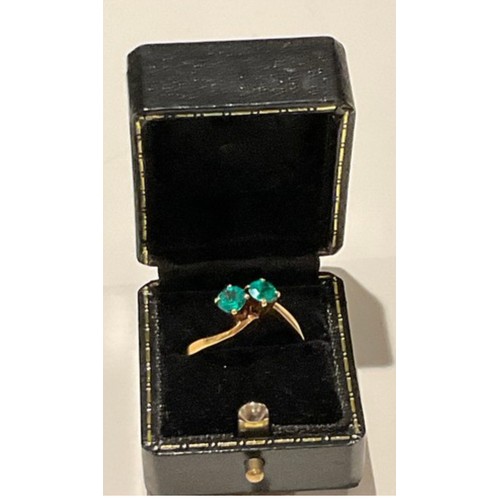 135 - 18ct gold ring with 2 x deep royal green colour stones brilliant cut with cross over yellow gold mou... 