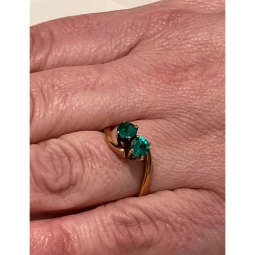 135 - 18ct gold ring with 2 x deep royal green colour stones brilliant cut with cross over yellow gold mou... 