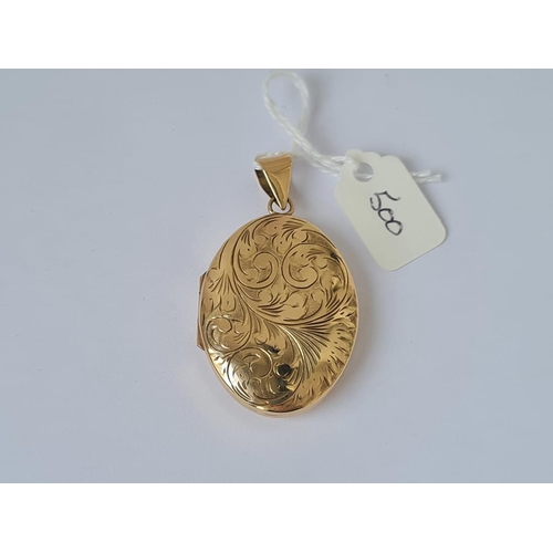 500 - A large scroll engraved oval locket in 9ct 11.7g