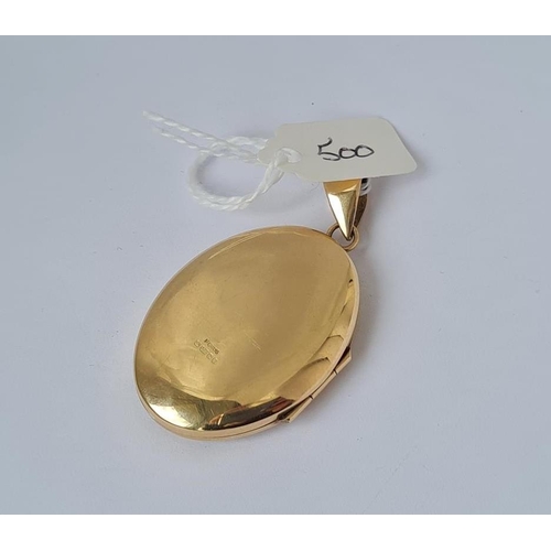 500 - A large scroll engraved oval locket in 9ct 11.7g