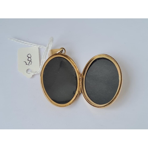 500 - A large scroll engraved oval locket in 9ct 11.7g