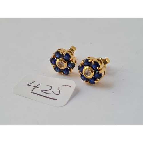 425 - A pair of diamond & sapphire cluster earrings set in gold