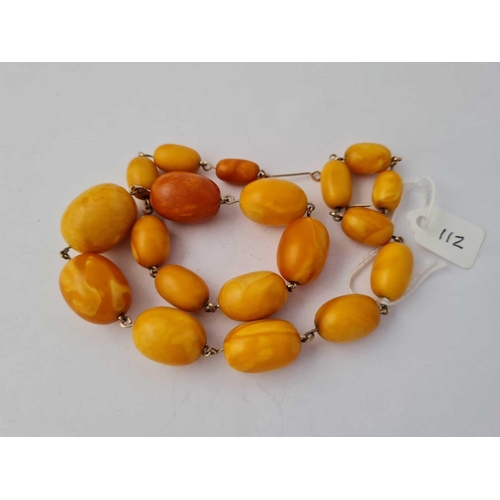 112 - A GRADUATED OVAL AMBER BEADS STRUNG ON WIRE LARGEST BEAD 26 MM X 17.7 MM DIA 17 INCHES IN LENGTH - 3... 