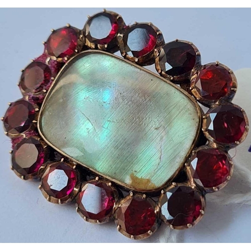 12 - A antique mourning brooch surrounded by 14 good garnets set in gold