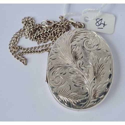 84 - A very large silver locket (5.5cm long) with floral scroll decoration on silver chain