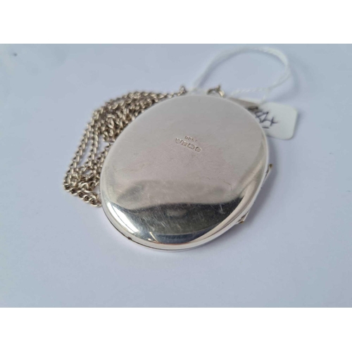 84 - A very large silver locket (5.5cm long) with floral scroll decoration on silver chain