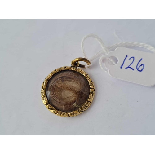 126 - A early Victorian circular glass fronted hair locket / pendant set in gold