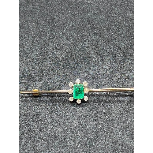 127 - A FINE GOLD BAR BROOCH WITH LARGE RETANGULAR CENTRAL EMERALD SURROUNDED WITH EIGHT DIAMONDS