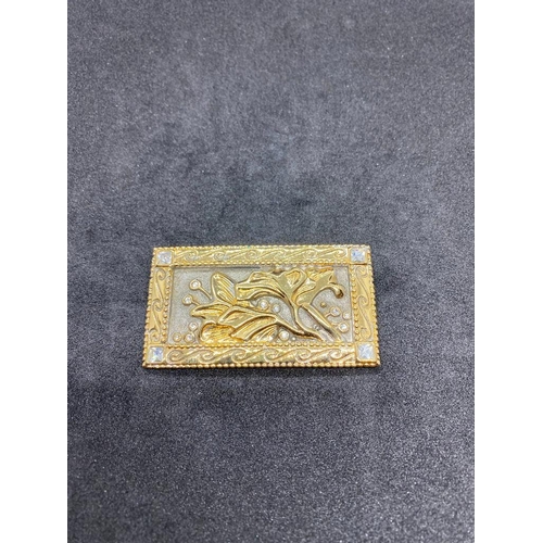 256 - A  gilt metal rectangular panel brooch with floral decoration and four stones one to each corner