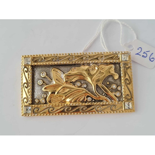 256 - A  gilt metal rectangular panel brooch with floral decoration and four stones one to each corner