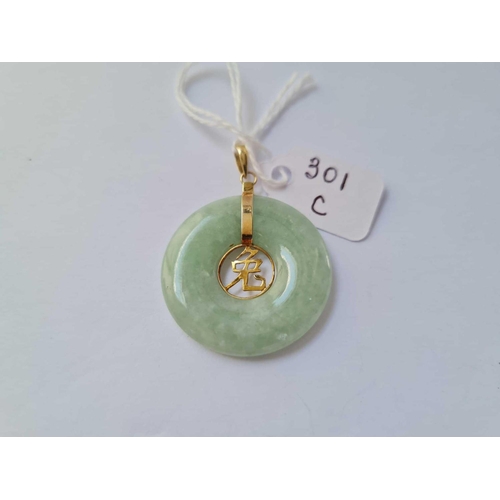 301c - A gold mounted jade disk pendant 14 ct gold - 7.5 gms