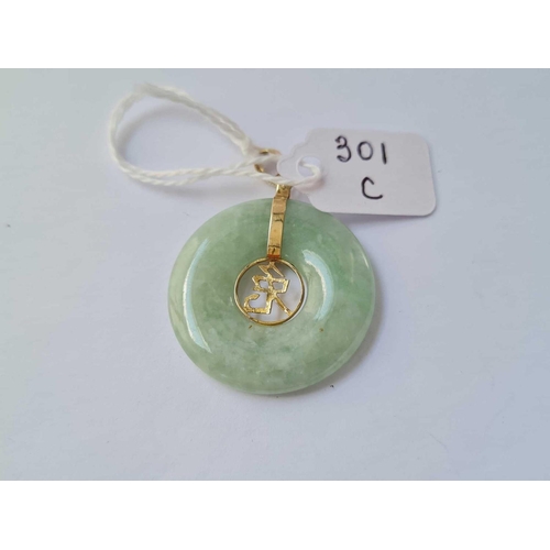 301c - A gold mounted jade disk pendant 14 ct gold - 7.5 gms