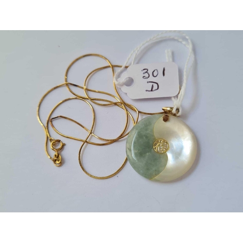 301d - A smaller gold mounted jade disk pendant on 14ct gold chain