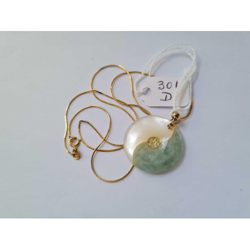 301d - A smaller gold mounted jade disk pendant on 14ct gold chain