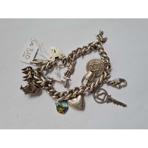 310 - A silver curb charm bracelet with numerous charms 57g