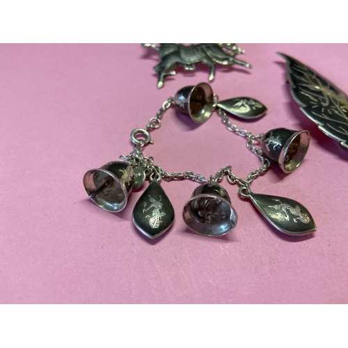 394 - A silver and yellow bracelet with bells and two brooches