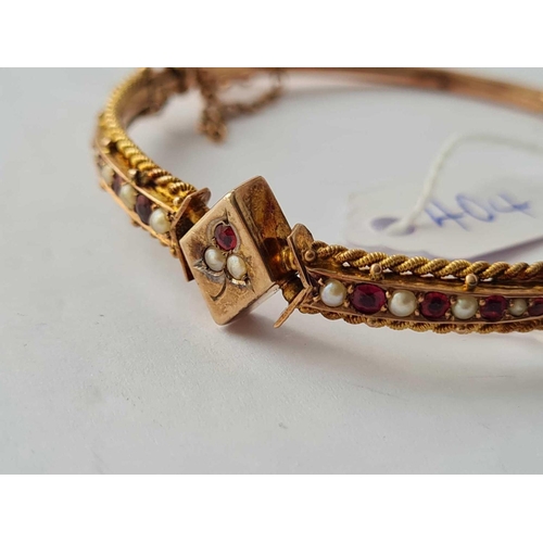 404 - A ROSE GOLD ATTRACTIVE BANGLE MOUNTED WITH RUBY AND PEARL PANELS OF LOZENGE SHAPED CENTRE SET IN 9CT... 